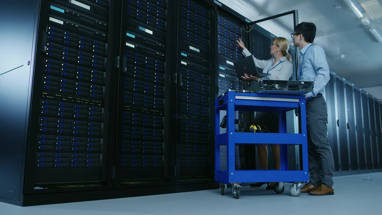 en el centro de datos moderno: el ingeniero y el especialista en it trabajan con racks de servidores, en un equipo de carrito para la instalación de nuevo hardware. especialistas que realizan mantenimiento y diagnóstico de la base de datos.