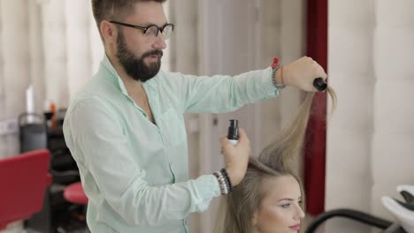 el peluquero profesional agrega polvo para el cabello al cabello de la modelo.