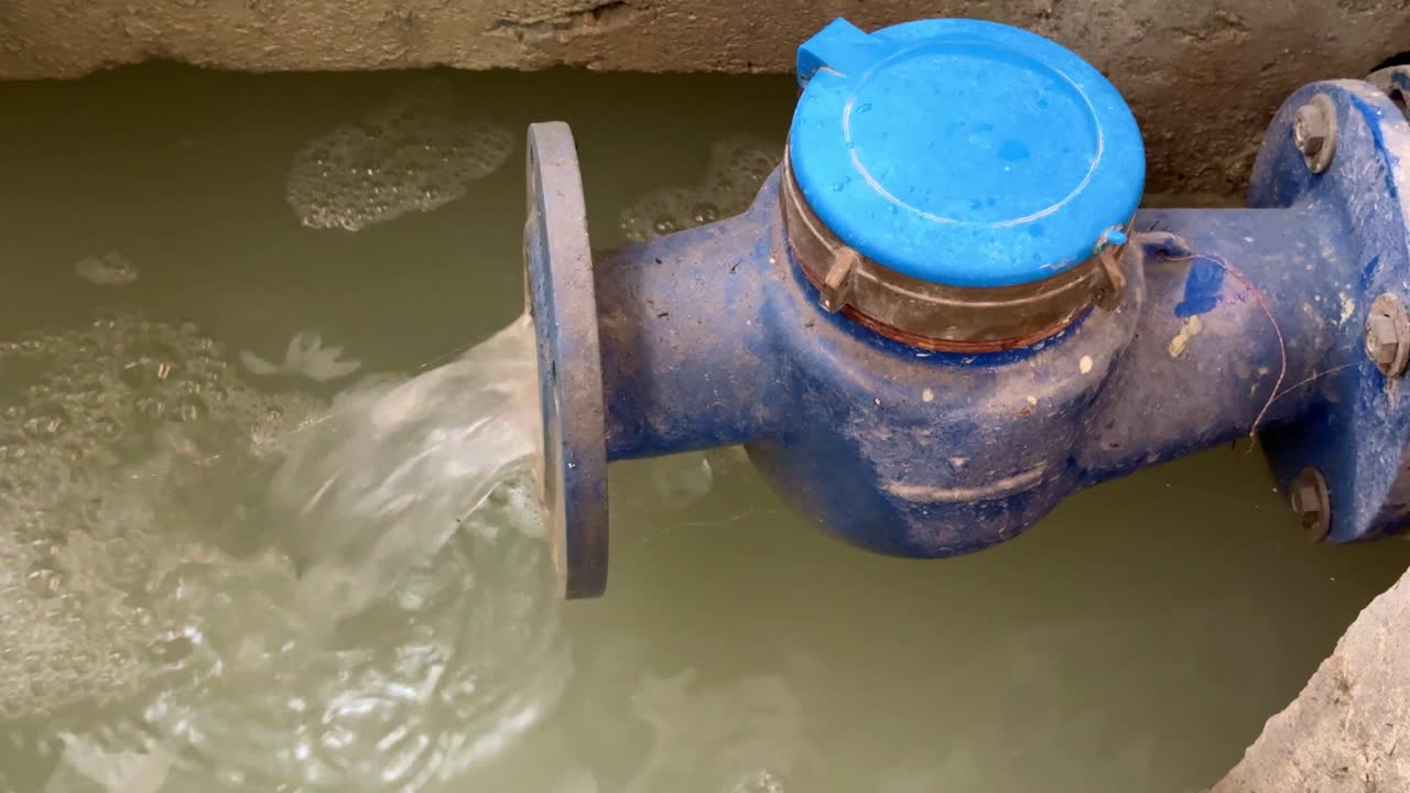 Utility pipe with blue water meter cap channeling wastewater into wastewater treatment plant