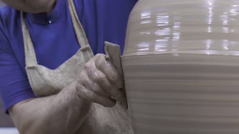 potter shaping clay on pottery wheel