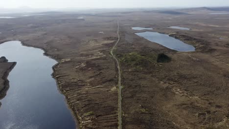 Toma-De-Un-Dron-De-Un-Camino-De-Vía-única-A-Través-De-Un-Paisaje-De-Páramos-Y-Turberas,-Rodeado-De-Lagos