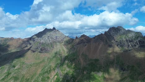 drone shot of valle de ip's rugged peaks under a vibrant blue sky in aragón, spain. sunlight dances over the landscape, highlighting the geological beauty. ideal for nature lovers