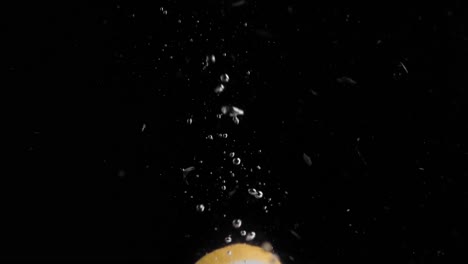 lemon slice falling into water super slowmotion, black background, lots of air bubbles, 4k240fps