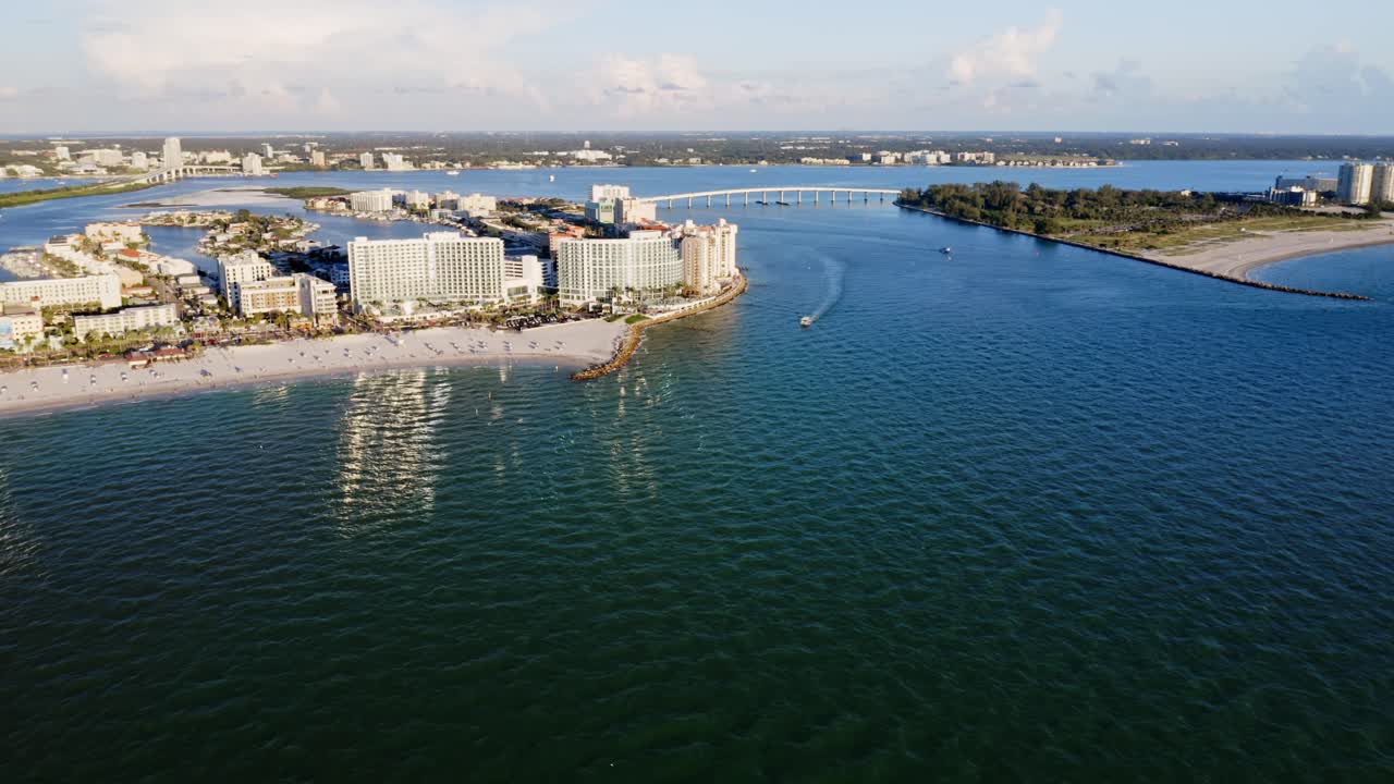 Resorts line the sandy shoreline of Clearwater Beach as a bridge extends across the inland waterways, connecting the Gulf coast to nearby residential areas