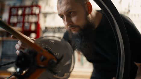 master rotates bicycle wheel - the chain and gears to test bicycle, close up