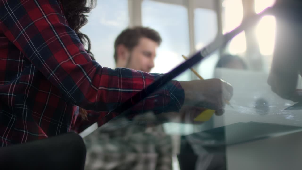 una mujer joven en una reunión hace una nota escrita a mano en una tarjeta en la nueva sala de conferencias