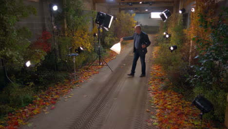 man on an autumn path studio set with photography lighting