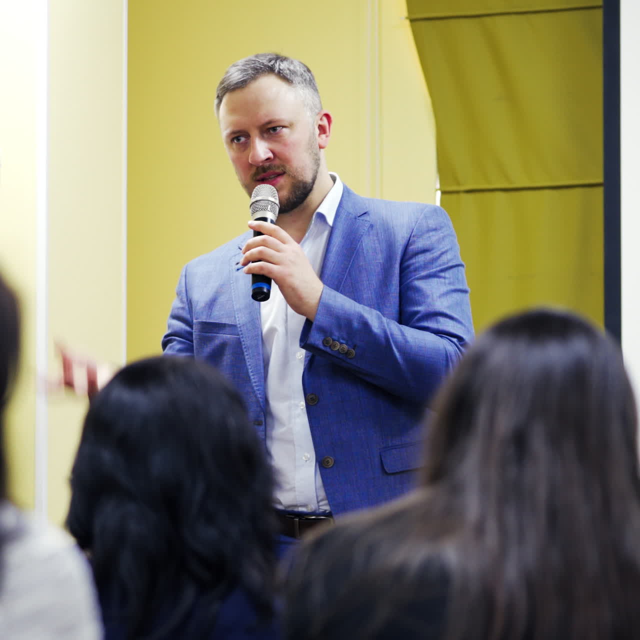 Speaker on the podium. People at the conference hall. Rear view