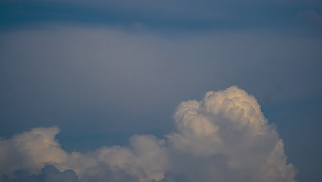 clouds roll building and receeding into nothing on pastel sky glowing with a tint of yellow