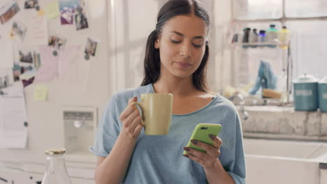 Young-student-using-smart-phone-at-home-in--morning-drinking-coffee