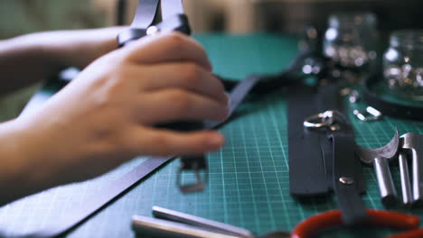 un sastre profesional hace ligas de cuero negro de moda