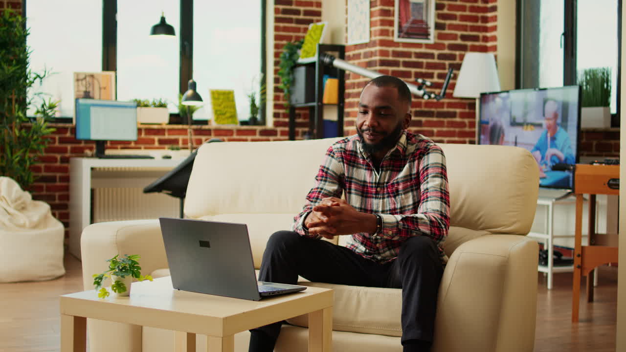 Man using laptop for video call in living room