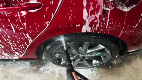 red car being washed at a detailing station