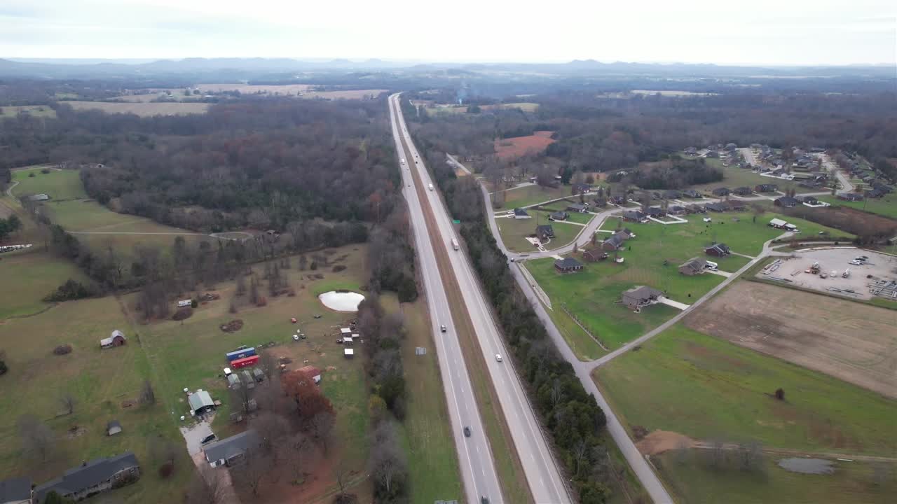 Scenic drone shot flying above the Kentucky Bluegrass Parkway, showcasing a peaceful highway cutting through rural countryside