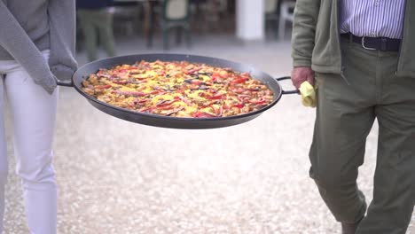 llevando paella a una reunión de personas celebrando
