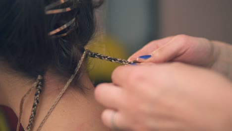 Closeup-view-of-the-hairdresser's-hands-doing-dreads-for-a-young-woman-in-the-hair-salon.-Shot-in-4k