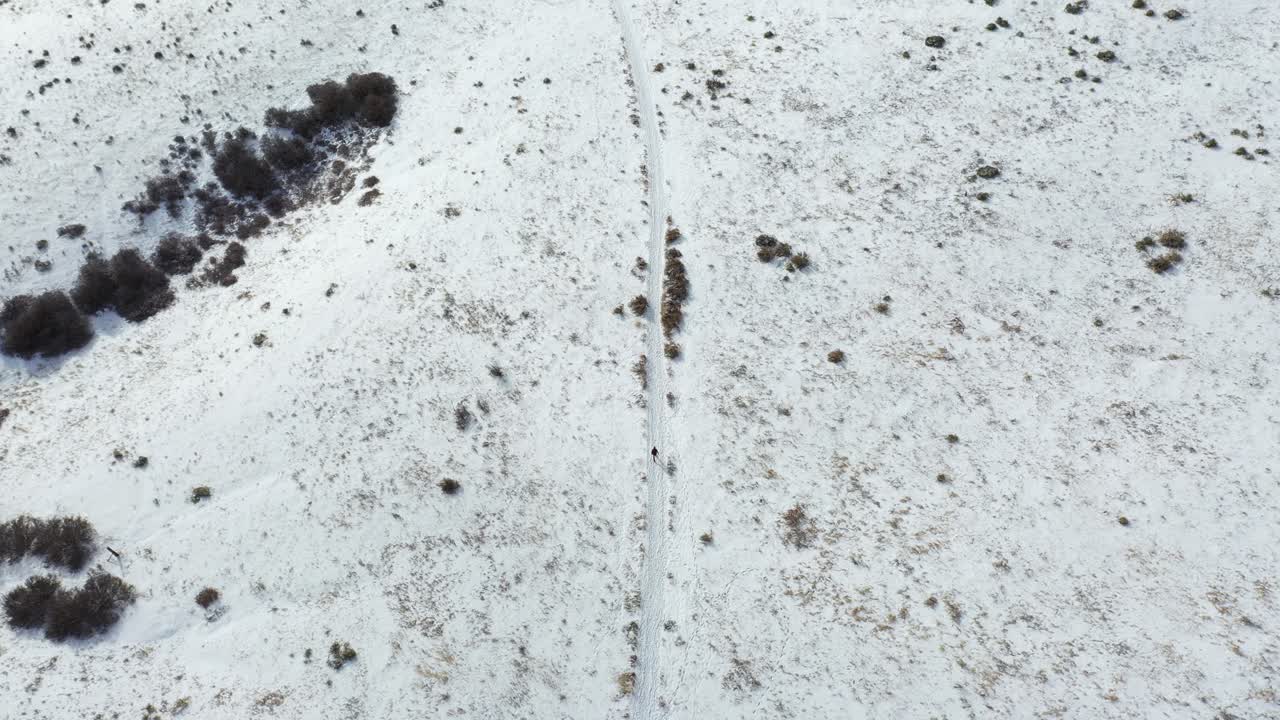 시골 산 풍경에서 눈 위를 걷는 외로운 사람