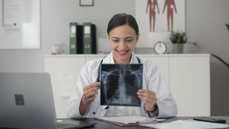 happy indian female doctor checking x ray report