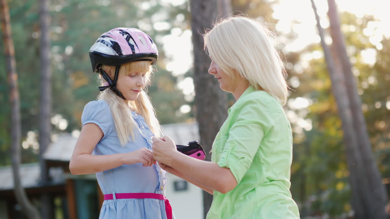 cuidado de los padres mamá viste hijas de coderas para andar en bicicleta o patines video 4k