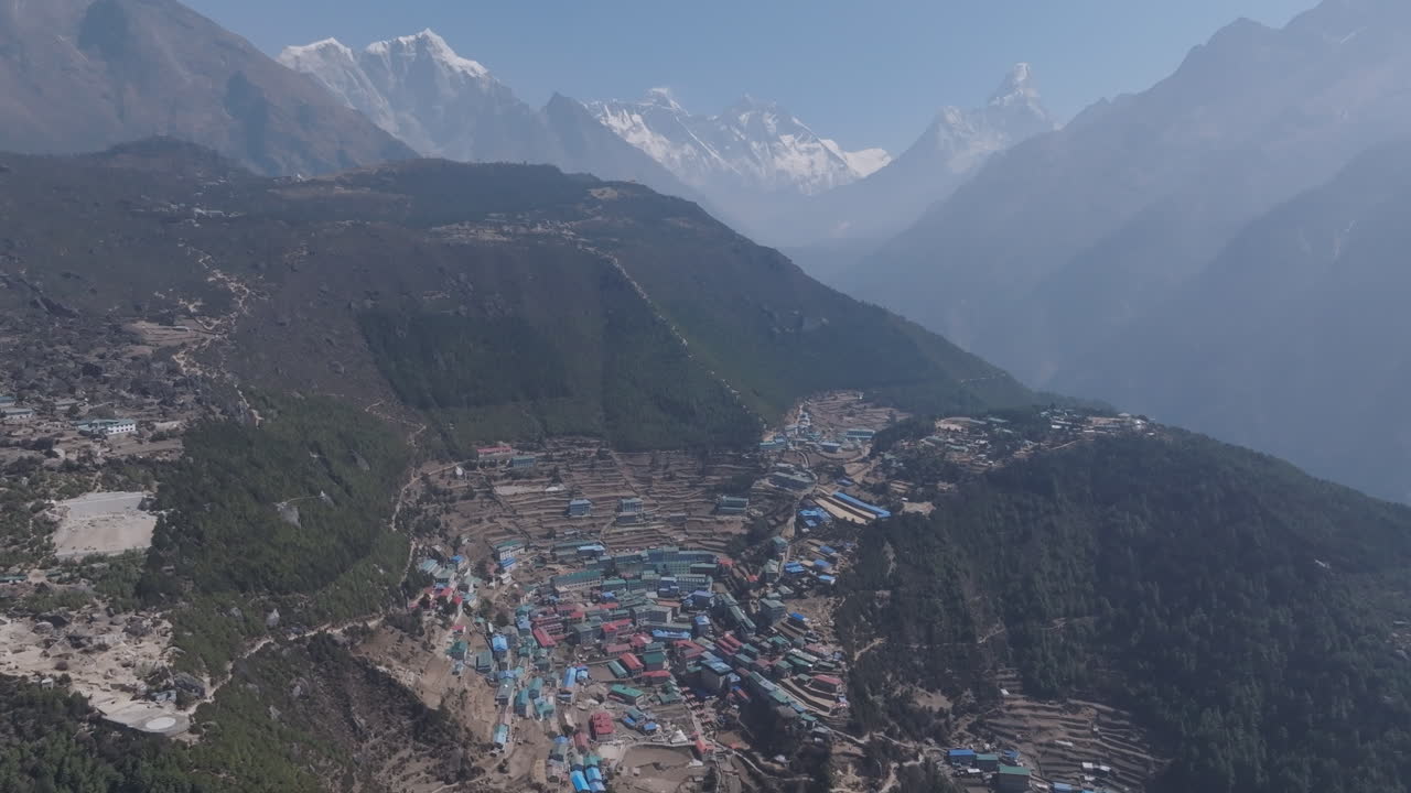 Drone shot Namche Village, gateway to Everest, shines under sunlight on Himalayan slopes, home to Sherpa community and serene high-altitude landscape of Nepal