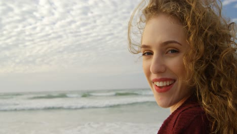 Primer-Plano-De-Una-Joven-Hermosa-Mujer-Caucásica-Sonriendo-Y-Mirando-A-La-Cámara-En-La-Playa-4k