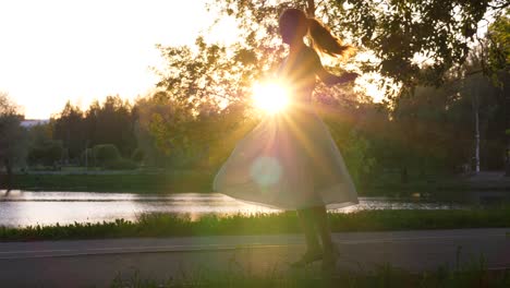 girl spin around in airy dress against setting sun.
