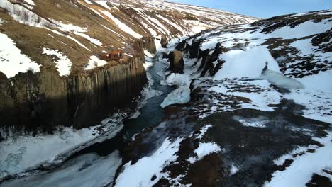 Exclusive-footage-captured-by-a-high-resolution-4K-drone,-offering-cinematic-and-bird's-eye-views-of-the-Icelandic-glaciers,-featuring-an-icy-creek-meandering-through-the-rocky-mountains