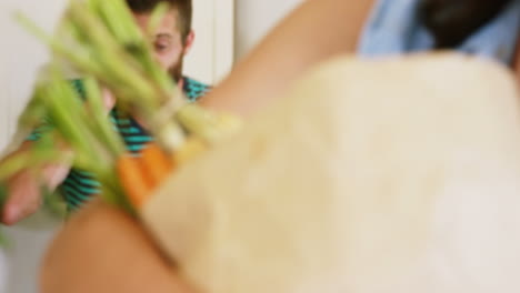 Man-calling-behind-woman-holding-grocery-bag