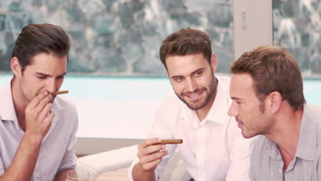 smiling friends smoking cigar in the living room