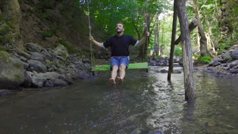 swinging on a swing over the stream. slow motion.
