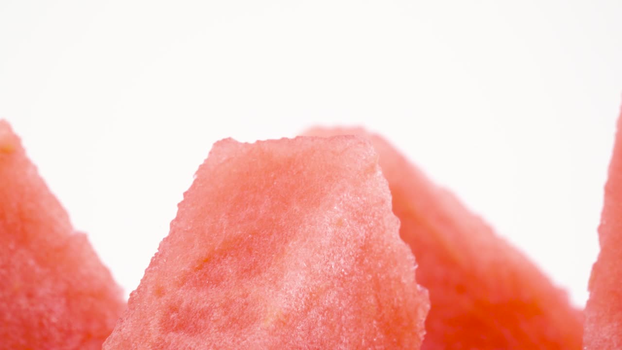 macro disparo de la parte superior de las rebanadas de sandía maduras. sección transversal. girando lentamente en la mesa giratoria aislada en el fondo blanco. primer plano.