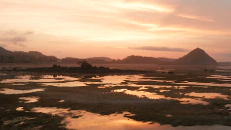 The-dry-reef-of-Kuta-Lombok-during-sunrise,-with-local-people-looking-for-food-and-seashells