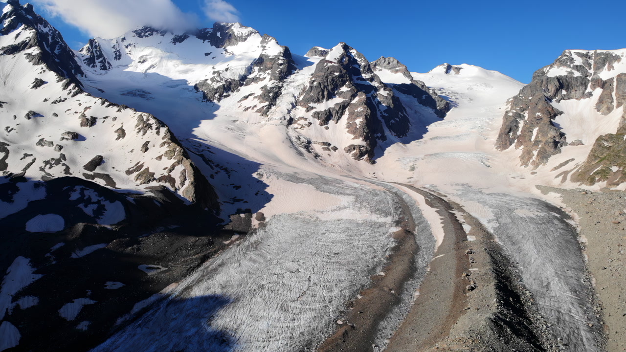 Aerial Glacier Valley With Snow Capped Peaks, Dramatic Drone Footage Showing Winding Ice River, Lateral. Media