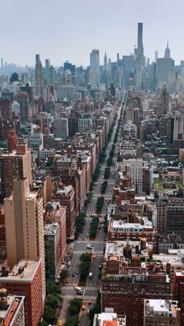 stunning scenery of new york at daytime. drone footage above the road leading through the beautiful quarters to downtown with skyscrapers. vertical video