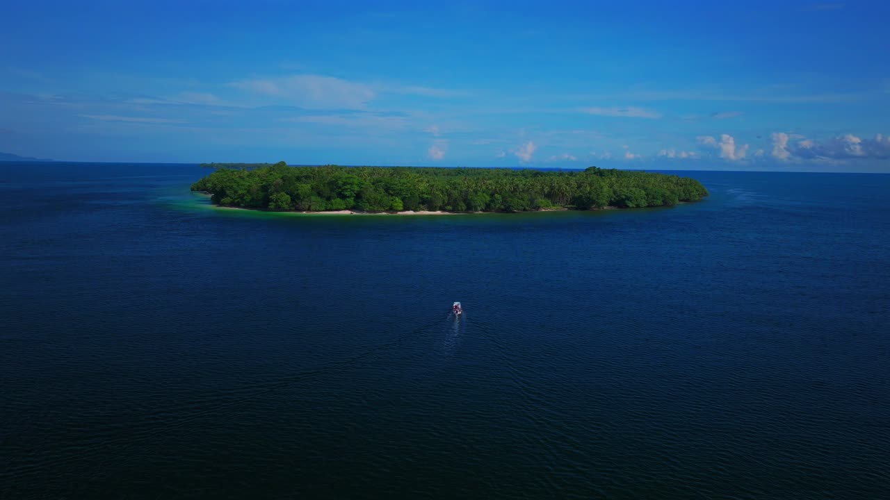 Fishing boat Yuo Island remote pristine untouched tropical coastline village Wewak Madang Cape Wom Papua New Guinea aerial drone PNG dry season summer morning blue sky static shot