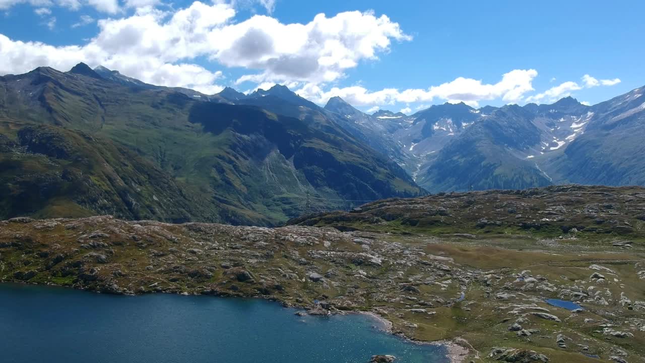 disparo de drones, panorámica y descenso sobre totensee en suiza, con una vasta cadena montañosa en el fondo