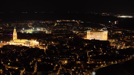 70mm drone filming of the city of toledo at night, we see its cathedral and its alcazar very illuminated, since they are its icons, the lights create that magic through its night streets.