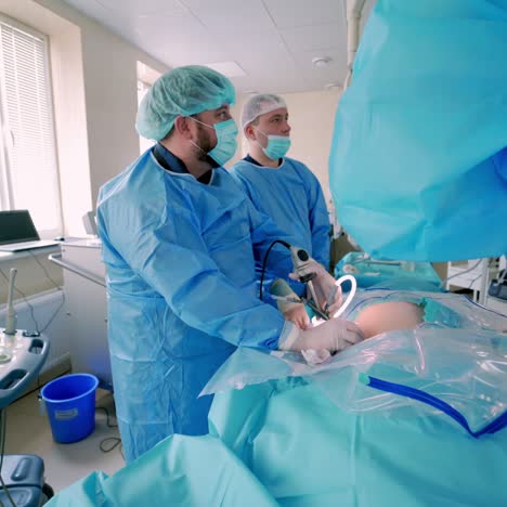 surgical process with the help of new medical equipment. contemporary equipment in the operating room. specialists in blue uniform perform an operation