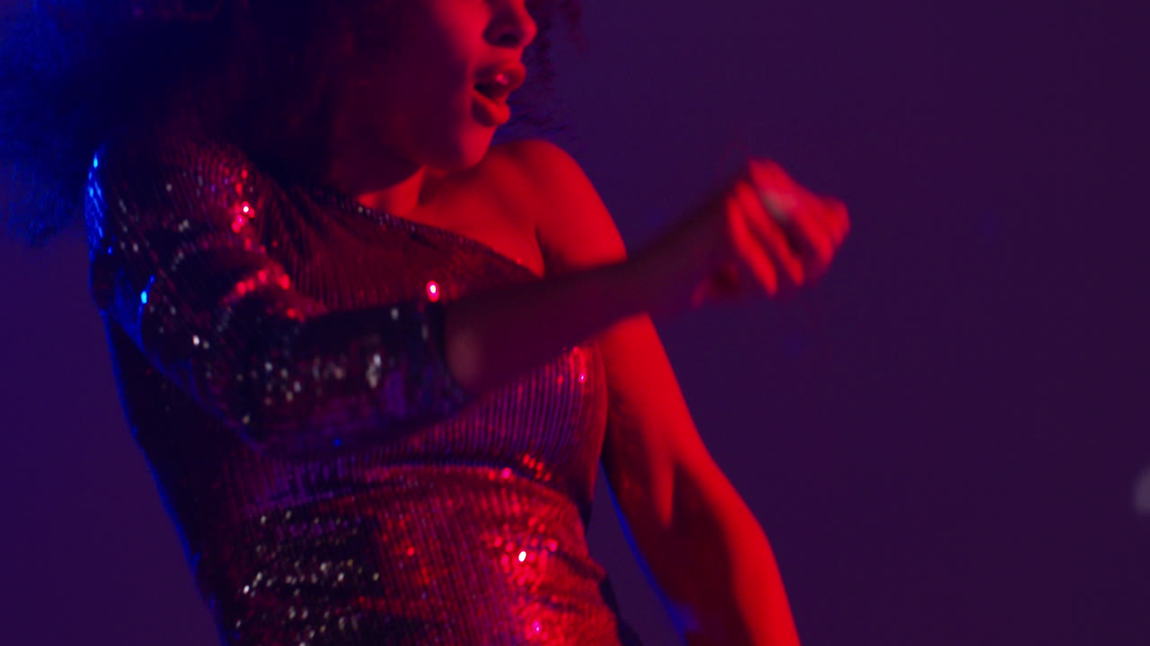 primer plano de una mujer joven en un bar de club nocturno o discoteca bailando con luces brillantes 11