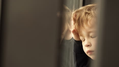 un niño mirando por la ventana.