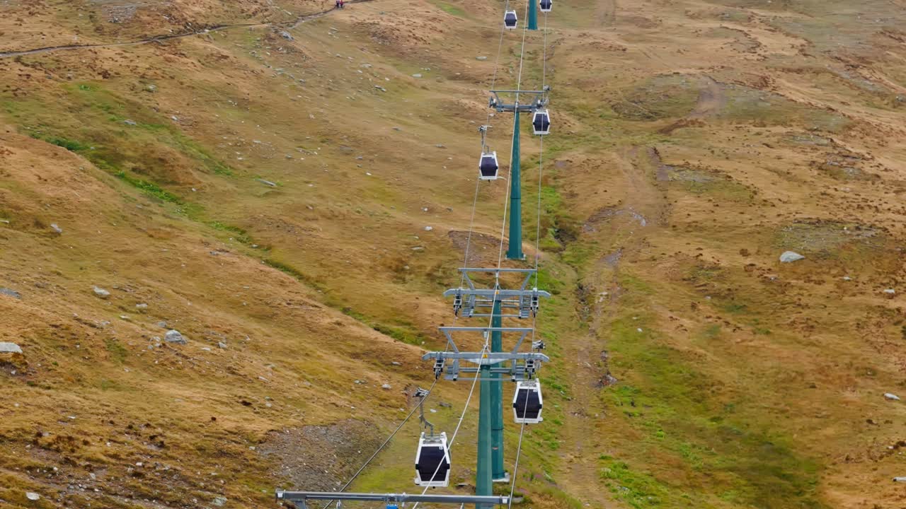 Aerial drone orbiting left shot of still cable cars in Cervinia, Italy, revealing alpine scenery and calm mountain resort atmosphere