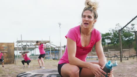 mujer caucásica agotada en el campamento de entrenamiento
