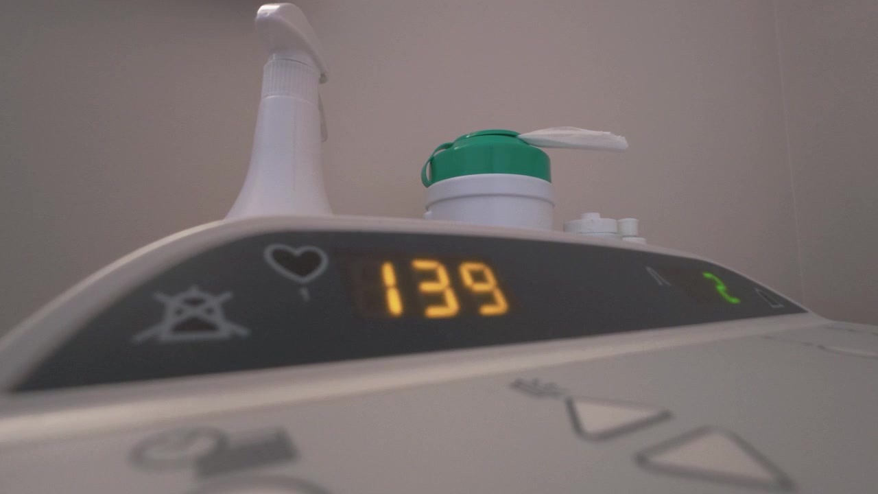 Primo piano di un monitor ospedaliero digitale che mostra una lettura del battito cardiaco in aumento in un ambiente clinico. Una luce ambientale soffusa evidenzia la tecnologia medica. Nessuna persona visibile.