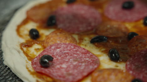 Making-italian-pizza-with-olives-and-salami