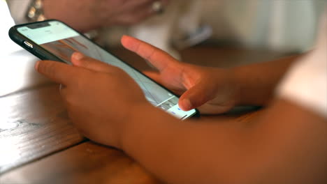 small south african boy operating a touch screen mobile phone