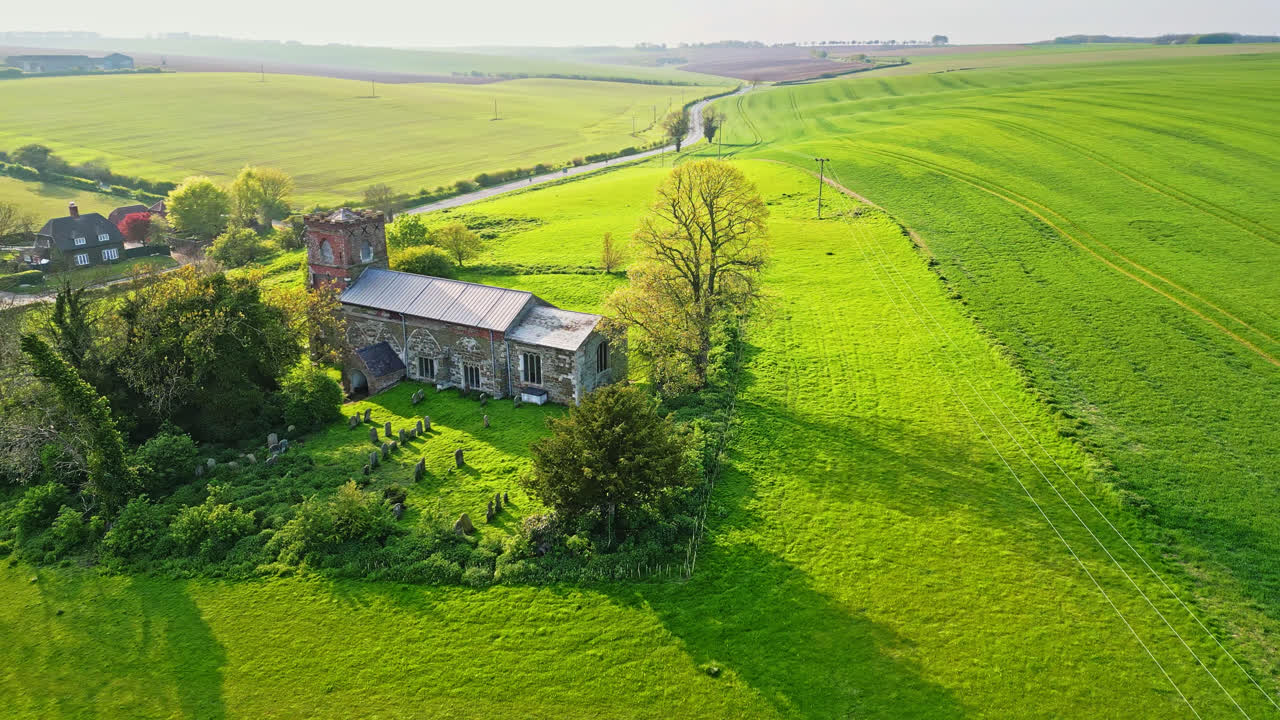 Drone video shows Burwell village, a former medieval market town, surrounded by rustic fields, historic red brick houses, and the unused Saint Michael parish church atop Lincolnshire's Wold Hills