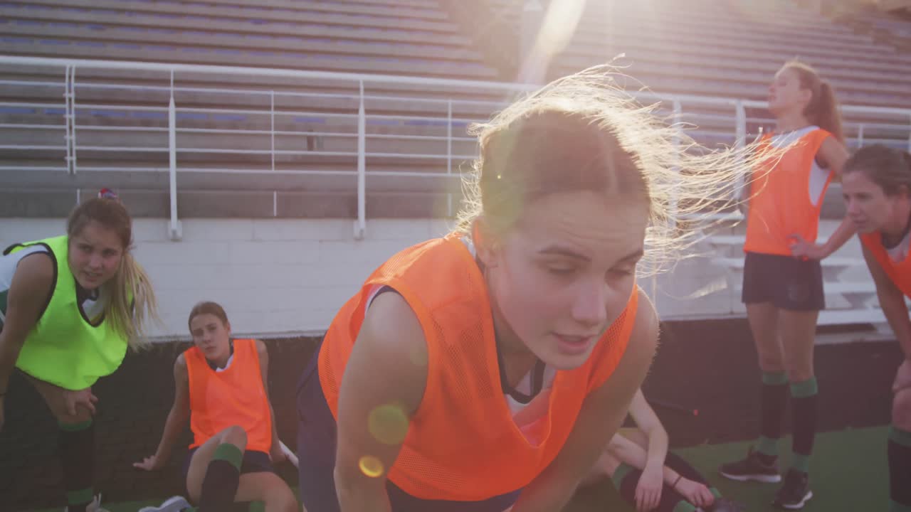 여자 하키 선수 들 이 경기장 에서 따뜻 해지고 있다