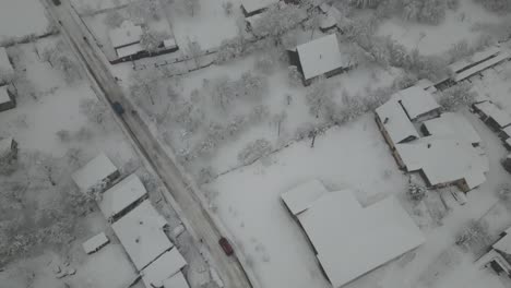 un hermoso camino en las montañas con casas, coches y nieve