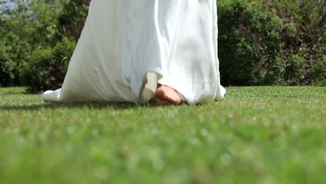 bride in wedding dress walking on grass