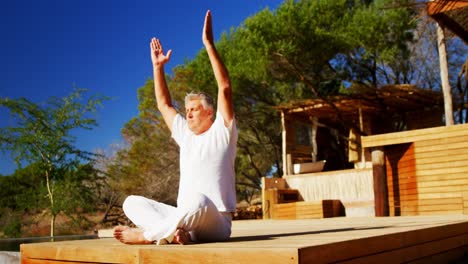 hombre mayor haciendo meditación en el resort 4k